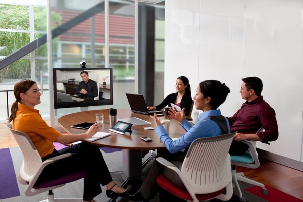 Team working at a wooden table with laptops and notebooks